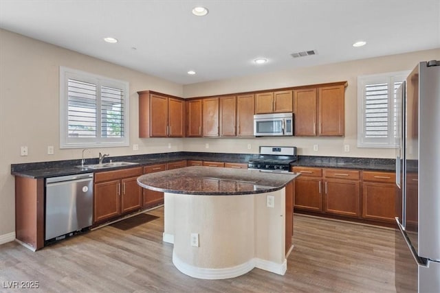 1121 Copper Grass St, Henderson, NV 89011 - kitchen featuring a sink, brown cabinetry, light wood-type flooring, appliances with stainless steel finishes, and visible vents