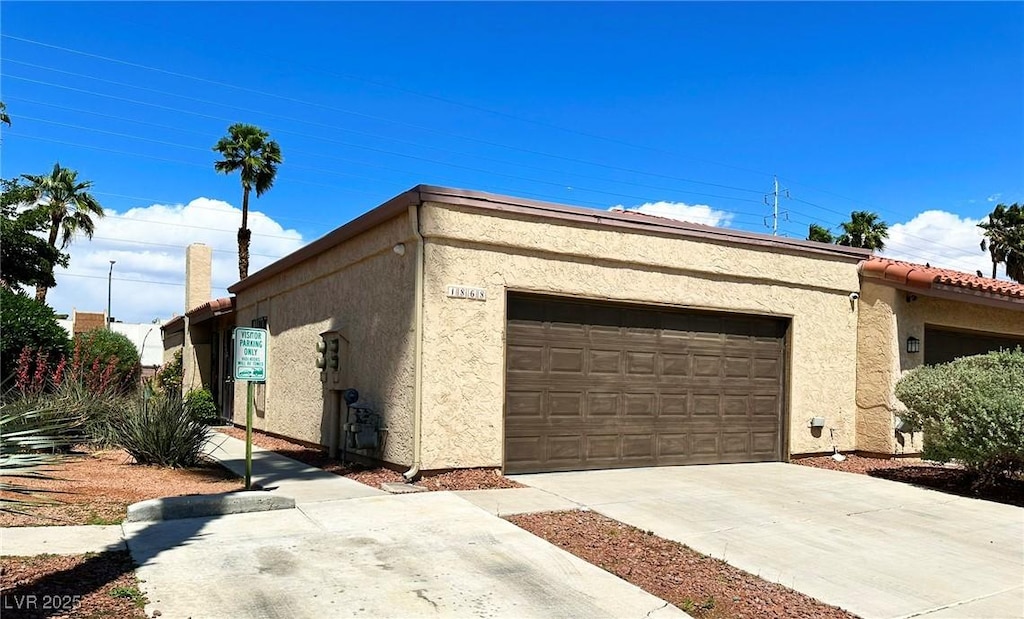 1868 Arbol Verde Way, Las Vegas, NV 89119 - view of side of property featuring stucco siding, driveway, and an attached garage