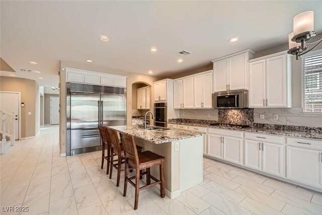 3428 Iron Hagen Ct, Las Vegas, NV 89141 - kitchen featuring marble finish floor, arched walkways, stainless steel appliances, and visible vents