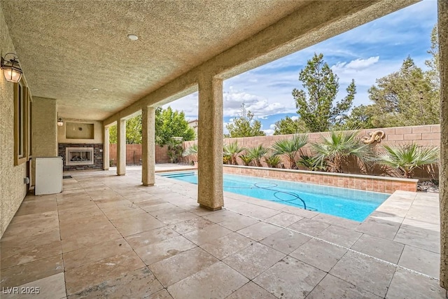 3428 Iron Hagen Ct, Las Vegas, NV 89141 - view of swimming pool with a fenced backyard, exterior fireplace, a patio area, and a fenced in pool