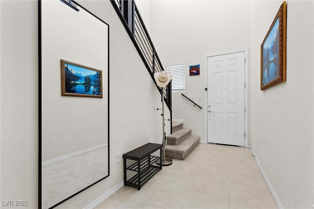 8107 Skye Sweep St, Las Vegas, NV 89166 - stairs featuring tile patterned floors, a towering ceiling, and baseboards