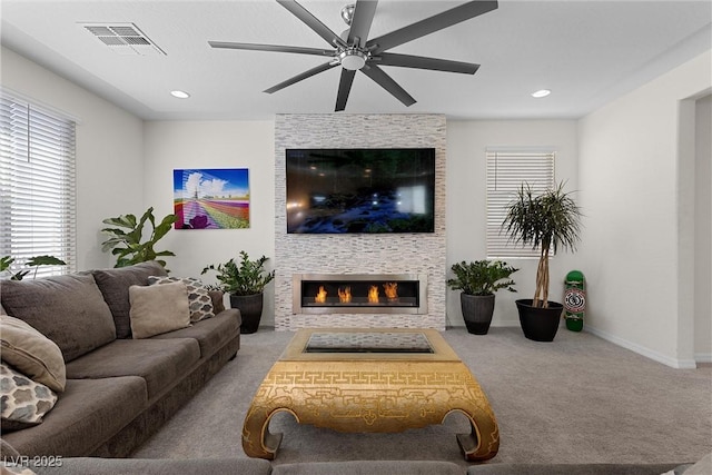 8107 Skye Sweep St, Las Vegas, NV 89166 - carpeted living room featuring a large fireplace, visible vents, a healthy amount of sunlight, and a ceiling fan