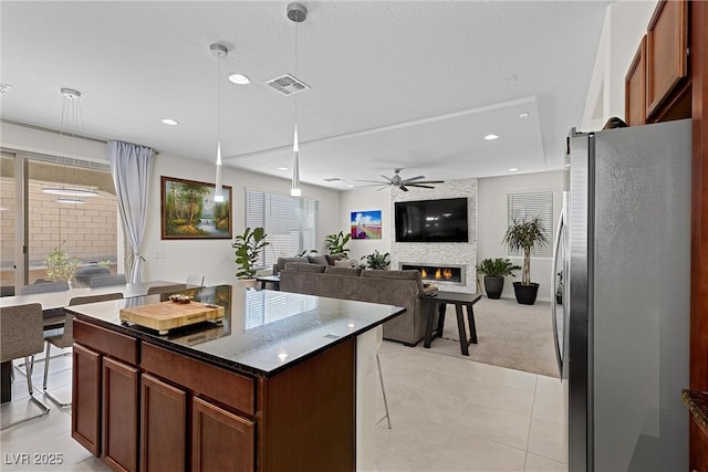 8107 Skye Sweep St, Las Vegas, NV 89166 - kitchen with a large fireplace, ceiling fan, visible vents, light carpet, and freestanding refrigerator