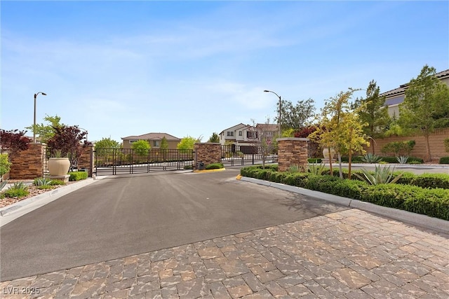 8107 Skye Sweep St, Las Vegas, NV 89166 - view of road with a gated entry, a gate, curbs, and street lighting