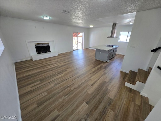 4754 Marnell Dr, Las Vegas, NV 89121 - unfurnished living room featuring visible vents, a textured ceiling, dark wood-type flooring, and a healthy amount of sunlight