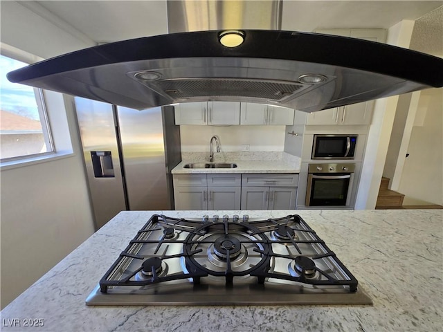 4754 Marnell Dr, Las Vegas, NV 89121 - kitchen with under cabinet range hood, light stone countertops, stainless steel appliances, and a sink