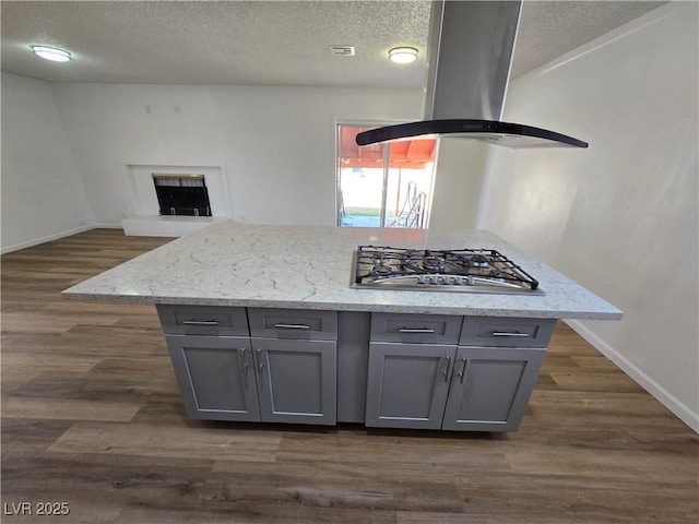 4754 Marnell Dr, Las Vegas, NV 89121 - interior details featuring island exhaust hood, gray cabinets, a textured ceiling, and stainless steel gas stovetop