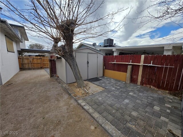 4754 Marnell Dr, Las Vegas, NV 89121 - view of patio with an outdoor structure, a storage unit, central AC, and a fenced backyard