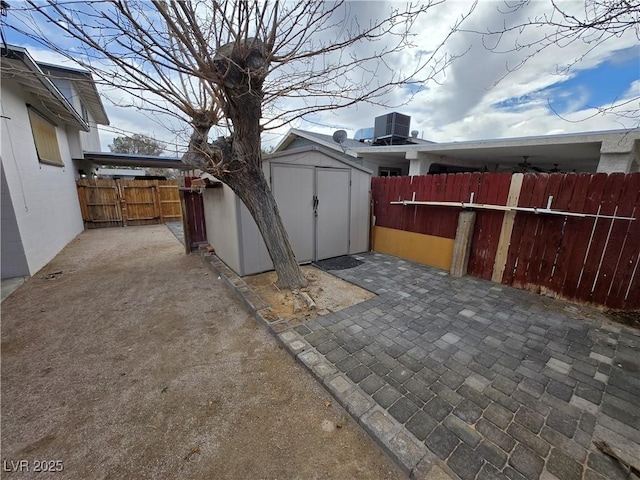 4754 Marnell Dr, Las Vegas, NV 89121 - view of patio with a fenced backyard, a storage unit, an outdoor structure, and central AC