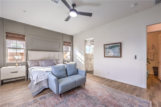 bedroom with baseboards, light wood finished floors, multiple windows, and visible vents