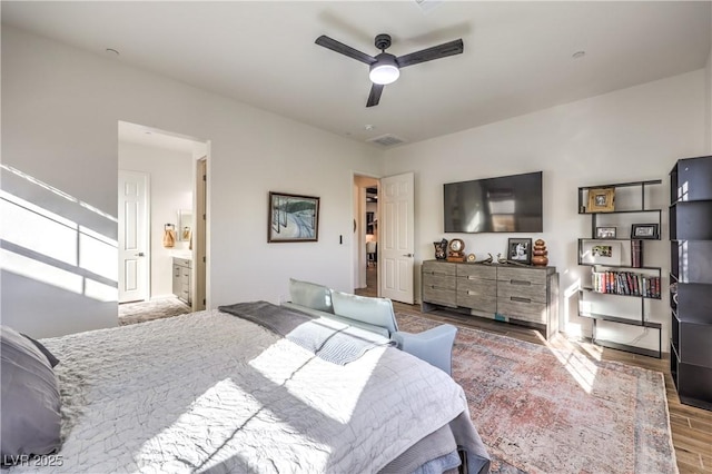 bedroom with wood finished floors, visible vents, and ceiling fan