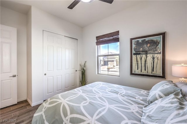 bedroom with baseboards, a ceiling fan, wood finished floors, and a closet