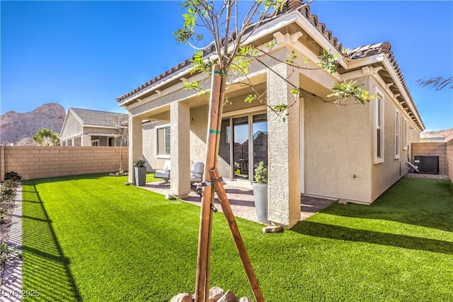 rear view of property featuring stucco siding, a patio, a fenced backyard, and central AC unit
