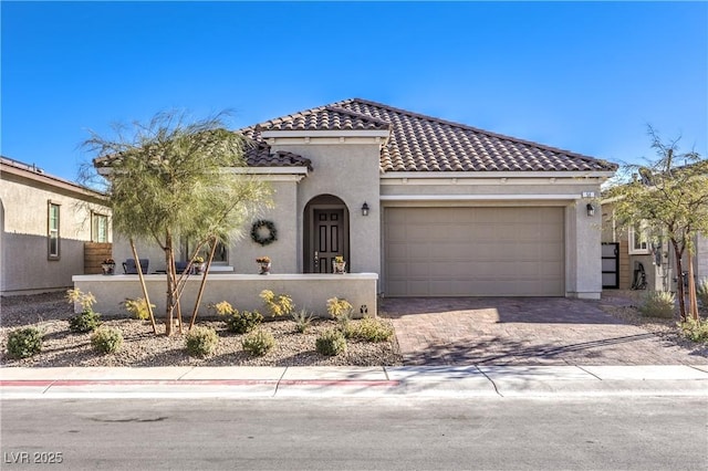 mediterranean / spanish home with stucco siding, fence private yard, a tiled roof, and a garage