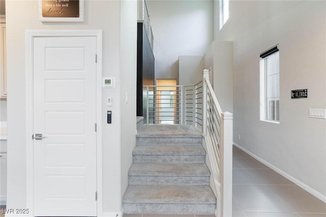 26 Lilla Rosa St, Henderson, NV 89011 - stairway featuring tile patterned floors, baseboards, and a towering ceiling