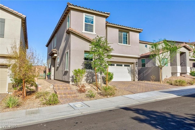 26 Lilla Rosa St, Henderson, NV 89011 - view of front of property featuring stucco siding, fence, decorative driveway, a tile roof, and an attached garage