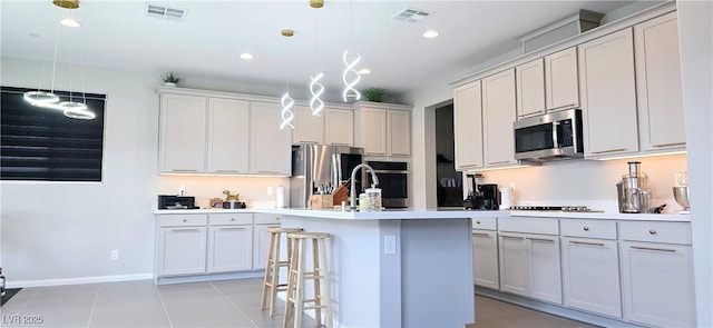26 Lilla Rosa St, Henderson, NV 89011 - kitchen with a kitchen island with sink, light tile patterned floors, visible vents, and stainless steel appliances