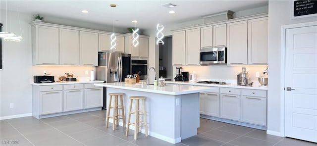 26 Lilla Rosa St, Henderson, NV 89011 - kitchen with a sink, visible vents, stainless steel appliances, light countertops, and an island with sink