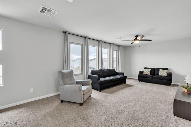 living room with light carpet, ceiling fan, and baseboards