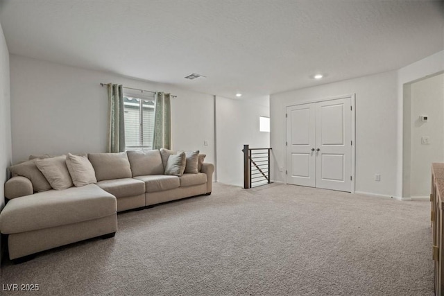 carpeted living area with visible vents and recessed lighting