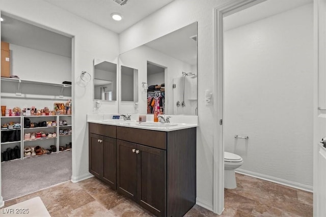 full bathroom with a spacious closet, a sink, double vanity, and toilet