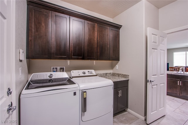 10470 Irish Cliffs Ct, Las Vegas, NV 89149 - laundry area featuring a sink, cabinet space, independent washer and dryer, light tile patterned floors, and baseboards