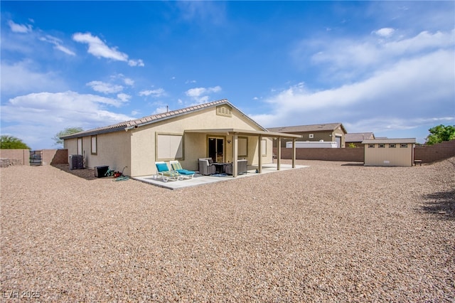 10470 Irish Cliffs Ct, Las Vegas, NV 89149 - back of house featuring a patio, central air condition unit, an outbuilding, a fenced backyard, and a storage shed