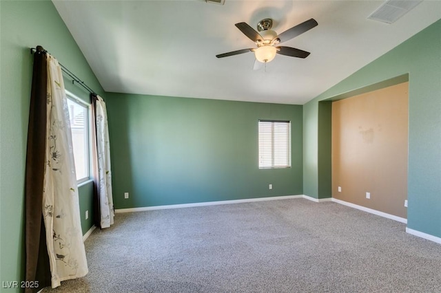 unfurnished room with vaulted ceiling, a healthy amount of sunlight, and carpet