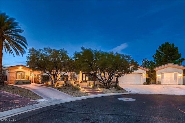 obstructed view of property with stucco siding, concrete driveway, and a garage