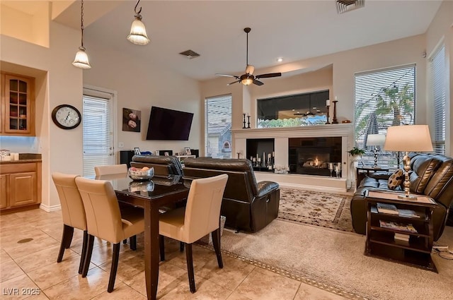 dining area with visible vents, light tile patterned floors, ceiling fan, and a fireplace