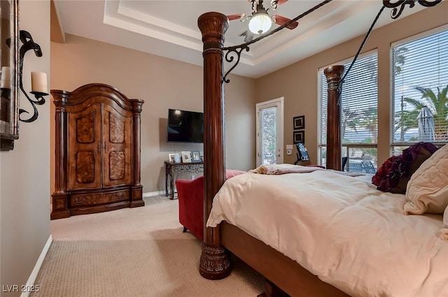 bedroom featuring carpet flooring, a raised ceiling, and baseboards