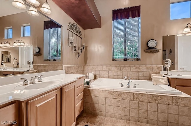 bathroom with tile patterned floors, a bath, and vanity