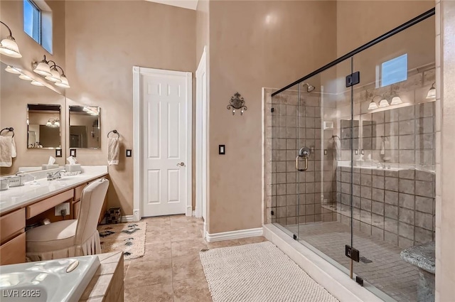 bathroom featuring tile patterned floors, a shower stall, vanity, baseboards, and a high ceiling