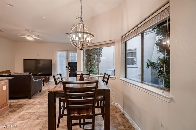 dining area with baseboards and ceiling fan with notable chandelier