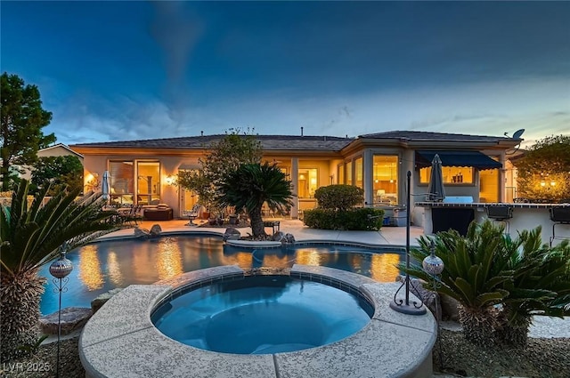 view of pool featuring a pool with connected hot tub and a patio area