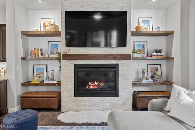 living room with baseboards, wood finished floors, a fireplace, and recessed lighting