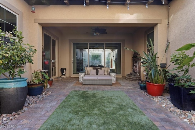 property entrance with stucco siding, a patio, and ceiling fan
