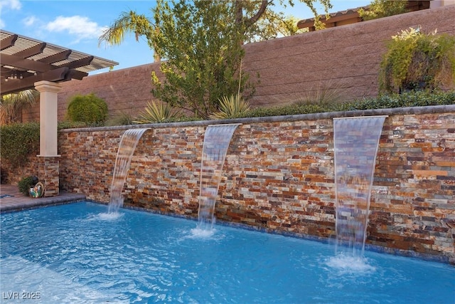 view of pool with fence and a pergola