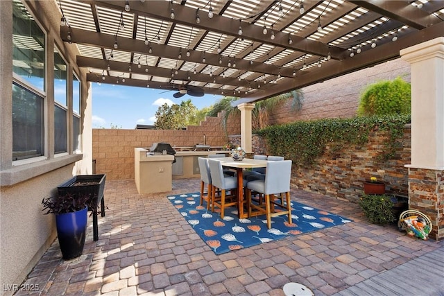 view of patio featuring exterior kitchen, a pergola, and a fenced backyard