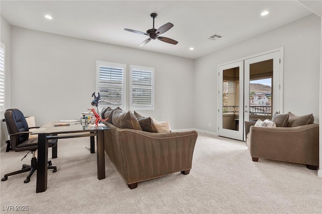 living area with light carpet, a ceiling fan, visible vents, and baseboards