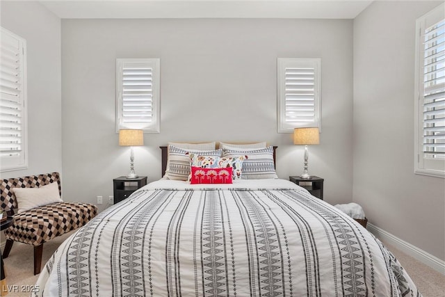 bedroom featuring baseboards and carpet