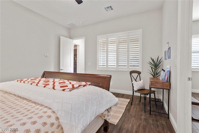 bedroom with baseboards, wood finished floors, visible vents, and a ceiling fan