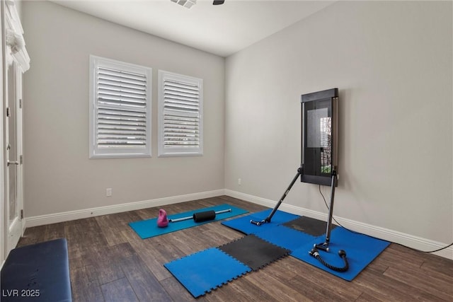 exercise area with baseboards and wood finished floors
