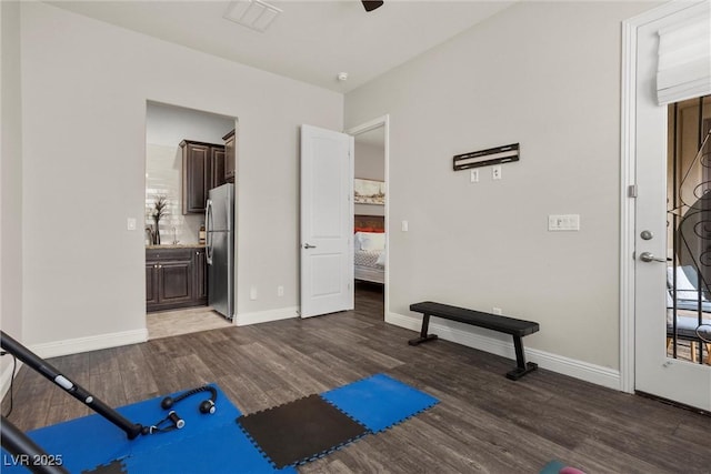 workout room featuring ceiling fan, baseboards, and wood finished floors