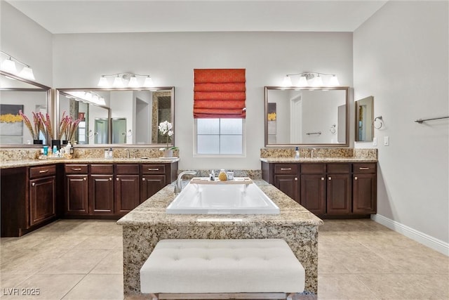 full bath with tile patterned floors, a garden tub, and a sink