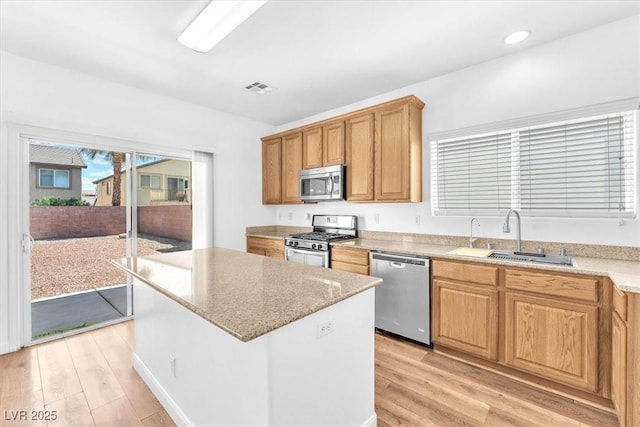 5060 Blue Rose St, North Las Vegas, NV 89081 - kitchen featuring a center island, a sink, light wood-type flooring, appliances with stainless steel finishes, and visible vents