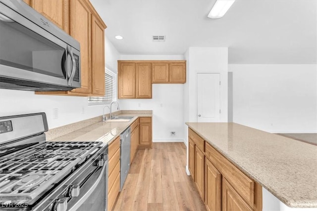 5060 Blue Rose St, North Las Vegas, NV 89081 - kitchen featuring recessed lighting, light stone counters, stainless steel appliances, a sink, and light wood-type flooring