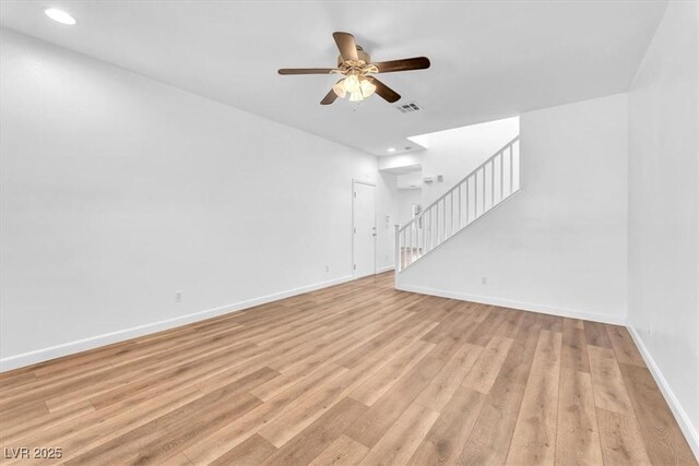 5060 Blue Rose St, North Las Vegas, NV 89081 - unfurnished living room with light wood-style flooring, baseboards, visible vents, ceiling fan, and stairway