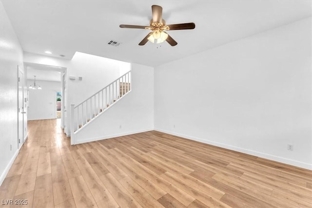 5060 Blue Rose St, North Las Vegas, NV 89081 - unfurnished living room with stairs, ceiling fan with notable chandelier, light wood-style flooring, visible vents, and recessed lighting