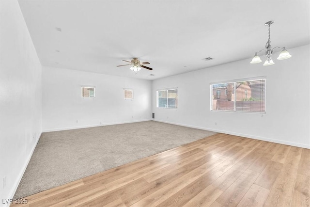5060 Blue Rose St, North Las Vegas, NV 89081 - unfurnished living room featuring visible vents, light wood finished floors, baseboards, and ceiling fan with notable chandelier